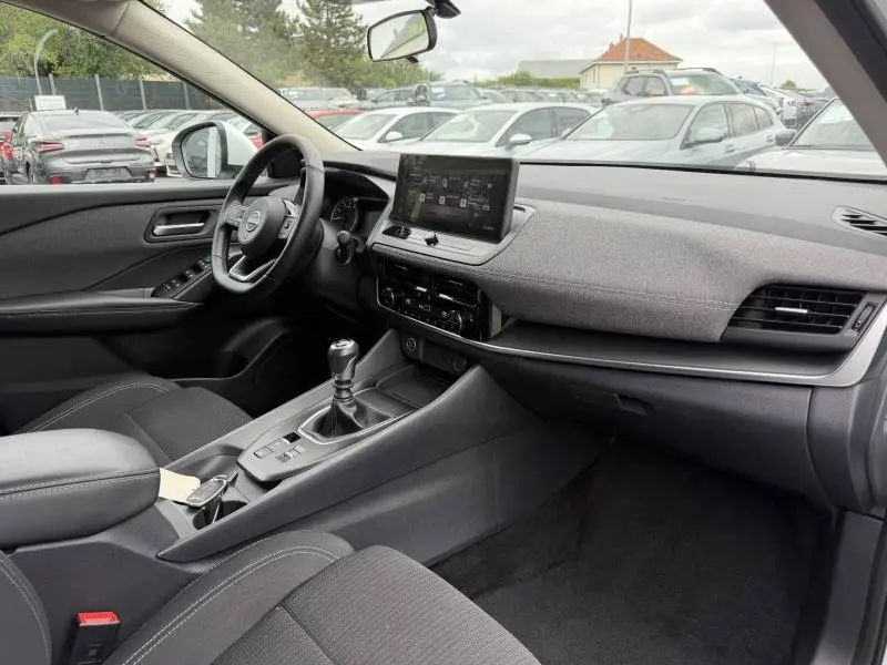 Vue intérieure côté conducteur du Nissan Qashqai 2025 avec volant cuir multifonction et écran tactile central.