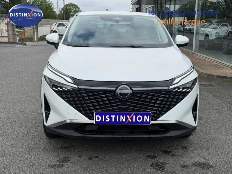 Vue avant d'un Nissan Qashqai blanc nacré avec calandre noire texturée et phares LED fins.