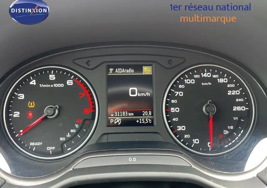 Vue rapprochée du tableau de bord de l'Audi Q2 noir, affichant compte-tours, vitesse et écran central numérique.