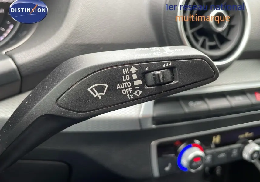 Gros plan sur la commande d'essuie-glace à gauche du volant dans l'habitacle d'un Audi Q2 noir Mito Metal 2023.