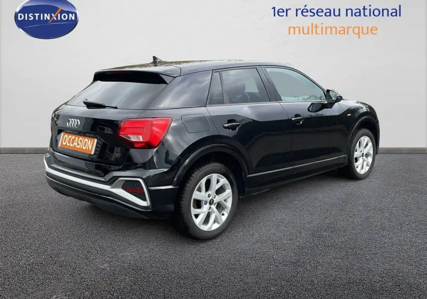 Audi Q2 noir mito metal vue 3/4 arrière côté droit, avec jantes argentées et feux arrière rouges.