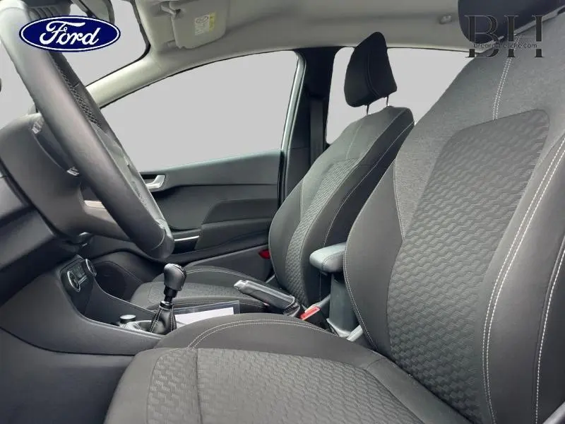 Vue intérieure côté conducteur de la Ford Fiesta 2022, sièges tissu noir Kasbah/Eton avec volant cuir et levier de vitesse manuel.