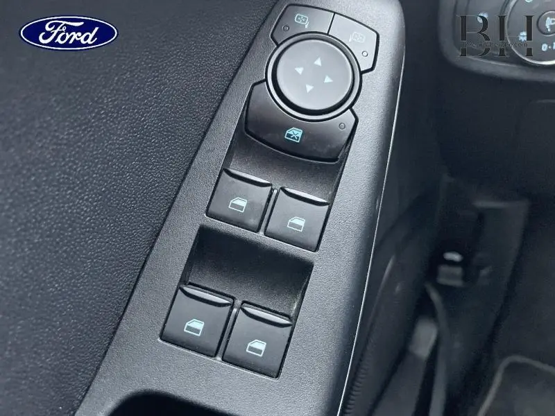 Gros plan sur les commandes des vitres électriques et rétroviseurs côté conducteur de la Ford Fiesta Titanium Business 2022.