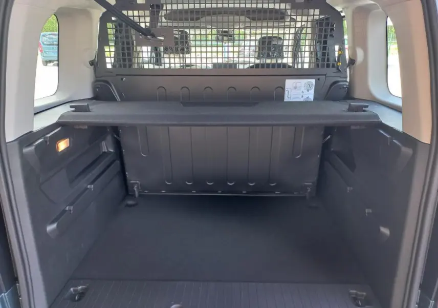 Vue intérieure du coffre arrière d'un Opel Combo Life M 2025, avec séparation grillagée et tablette de rangement noire.