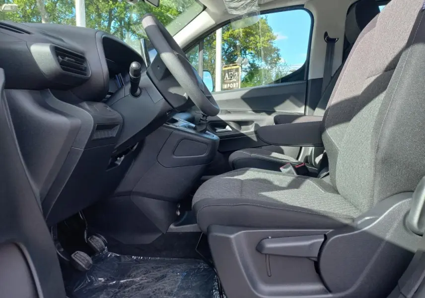 Vue intérieure côté conducteur de l’Opel Combo Life M 2025, sièges gris et tableau de bord noir simple.