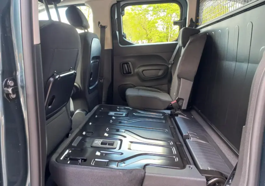 Vue intérieure côté droit de l’Opel Combo Life 2025 bleu, montrant la banquette arrière rabattue et les sièges avant.