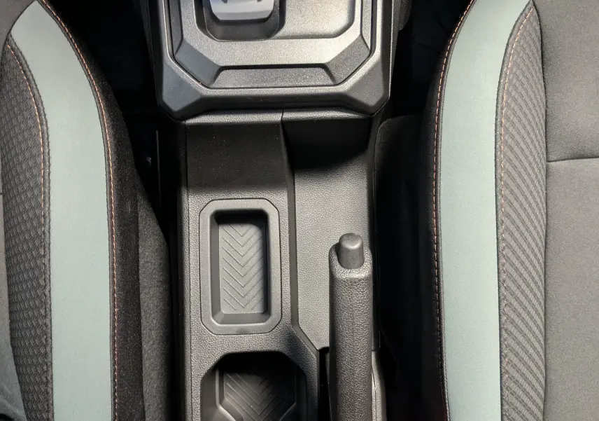 Vue plongeante sur la console centrale du Dacia Duster 1.6 Hybrid 140 Extreme avec levier de vitesse et sièges bicolores gris schiste.