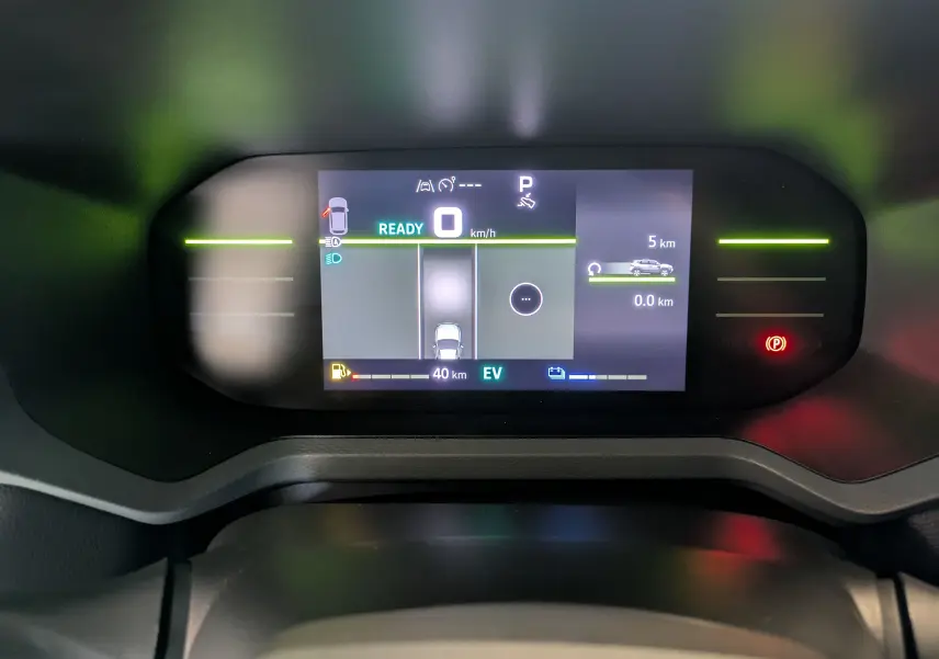 Tableau de bord numérique du Dacia Duster 1.6 Hybrid 140, affichant la vitesse, autonomie et mode EV.