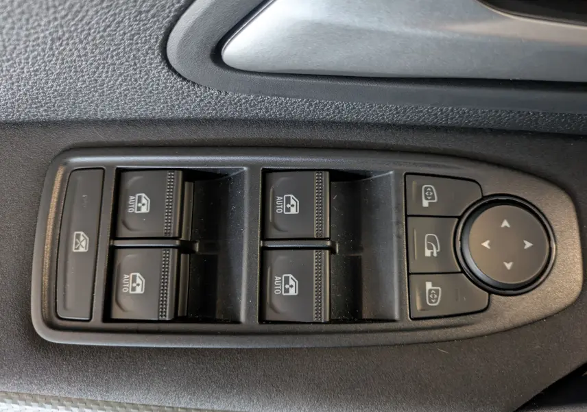 Panneau de commandes des vitres et rétroviseurs côté conducteur du Dacia Duster 1.6 Hybrid 140 gris schiste.