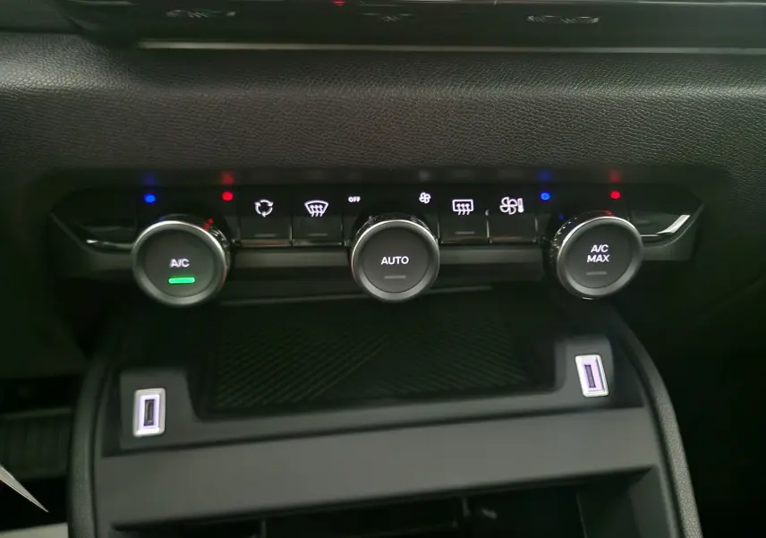 Gros plan sur la console centrale du Citroën C4 2025 blanc Okenite, montrant les commandes de climatisation automatique.