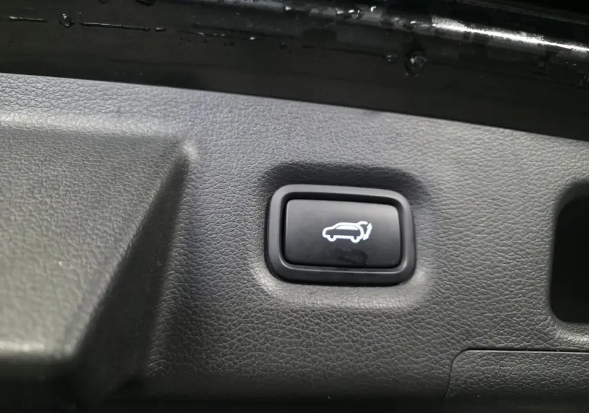 Bouton d'ouverture électrique du hayon sur le panneau intérieur du coffre du Hyundai Santa Fé noir 2023.