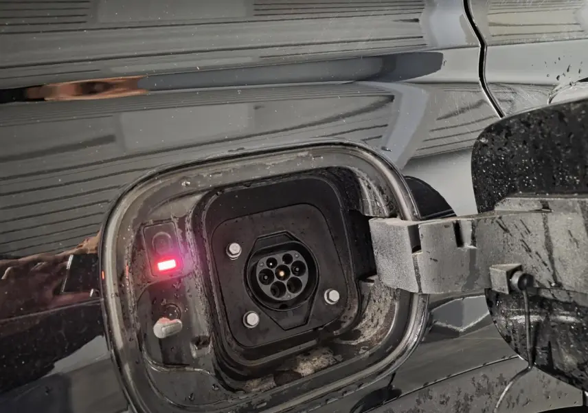 Prise de recharge hybride ouverte côté gauche sur Hyundai Santa Fé noir métallisé avec témoin lumineux rouge allumé