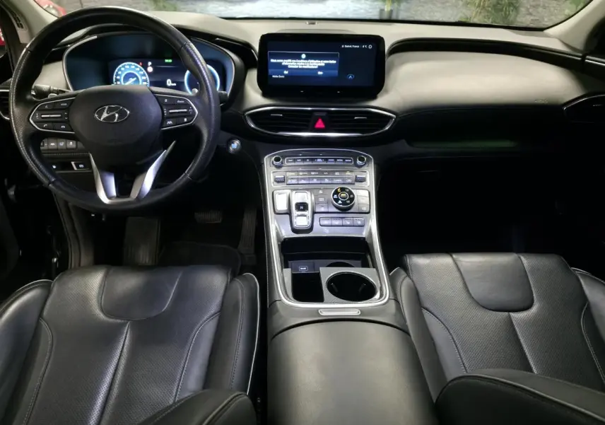 Intérieur noir du Hyundai Santa Fé 2023 vu de face, avec tableau de bord numérique et console centrale moderne.