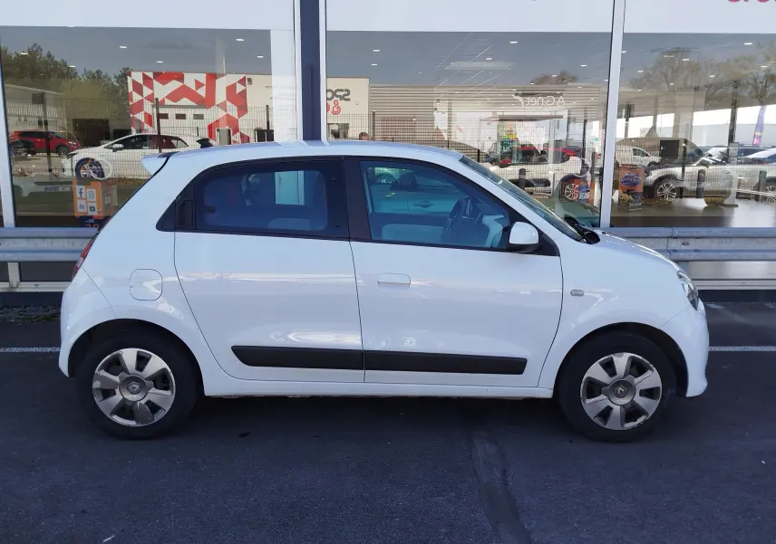 Renault Twingo blanc cristal vue de profil côté gauche, compacte avec baguettes noires sur les portières.