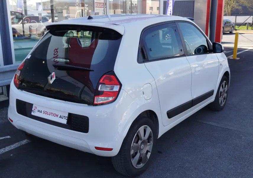 Renault Twingo blanc cristal vue 3/4 arrière droit, avec vitres teintées et jantes spécifiques Zen 2016.