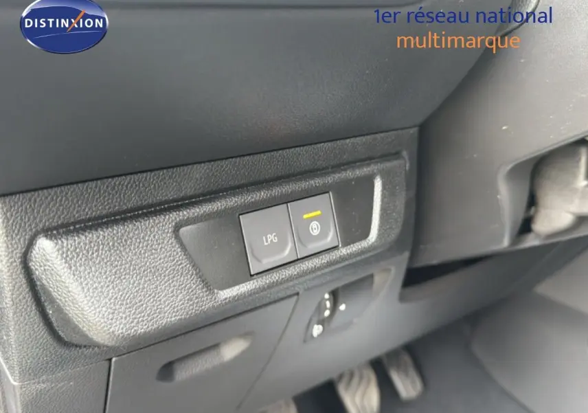 Gros plan sur les boutons LPG et frein de stationnement électrique dans l'habitacle du Dacia Jogger vert cèdre métal.