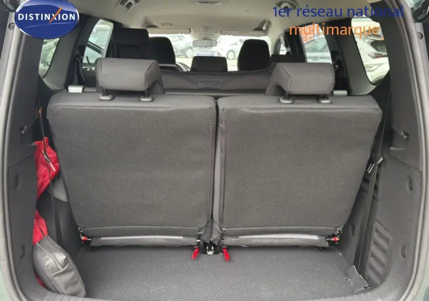 Vue arrière du coffre du Dacia Jogger vert cèdre, sièges arrière relevés et espace de chargement visible.