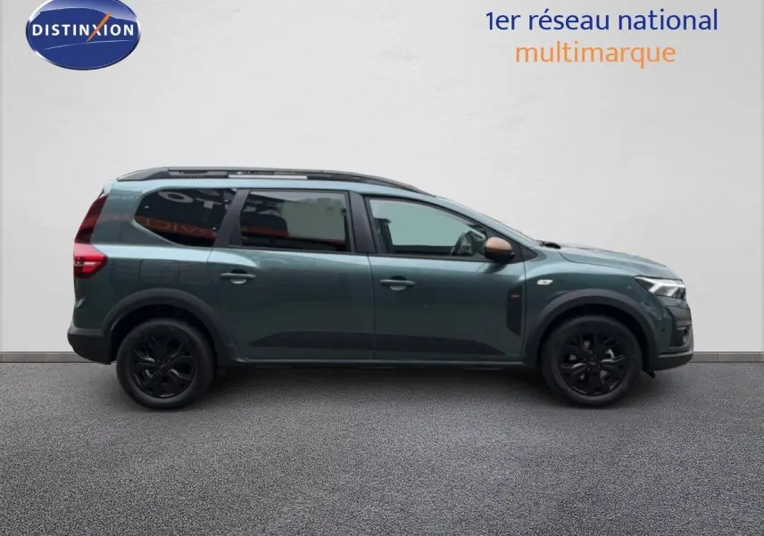 Vue latérale droite d'un Dacia Jogger 2026 vert cèdre métallisé avec jantes noires et toit ouvrant.