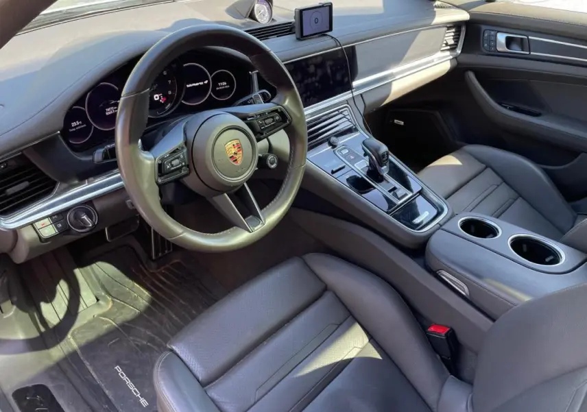 Vue intérieure côté conducteur de la Porsche Panamera 4 V6 Hybrid 2022, avec tableau de bord gris et console centrale moderne.