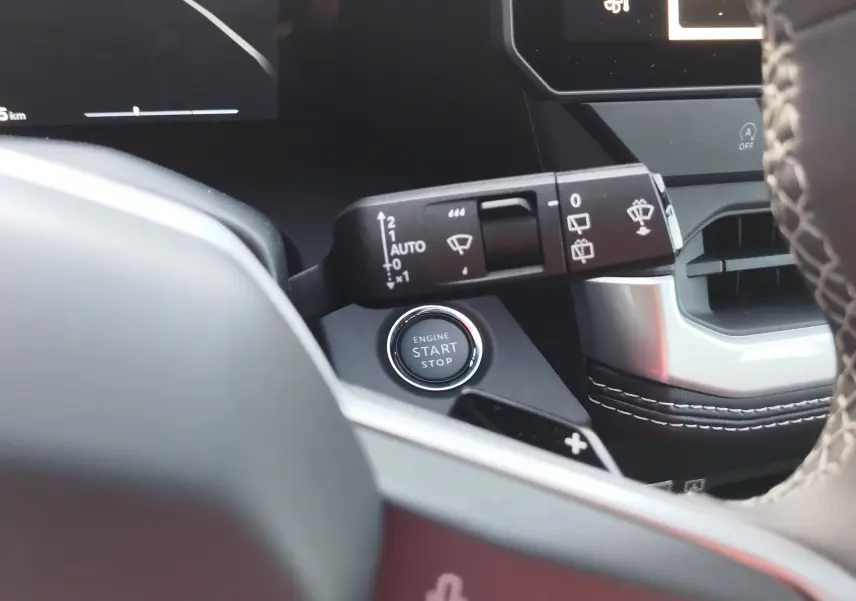 Détail intérieur du Jeep Compass 2026 noir Vulcano, montrant la commande des essuie-glaces et le bouton start/stop sur tableau de bord.