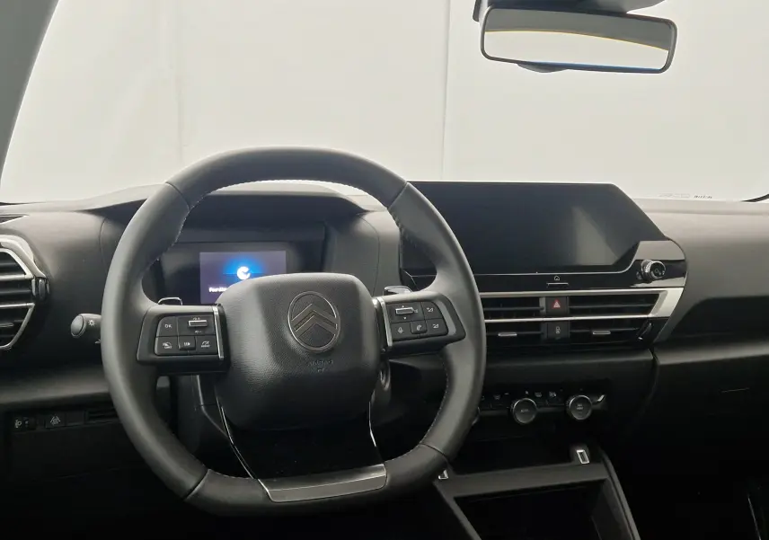 Intérieur noir de la Citroën C4 2025, vue frontale du volant cuir et tableau de bord avec écran tactile large.