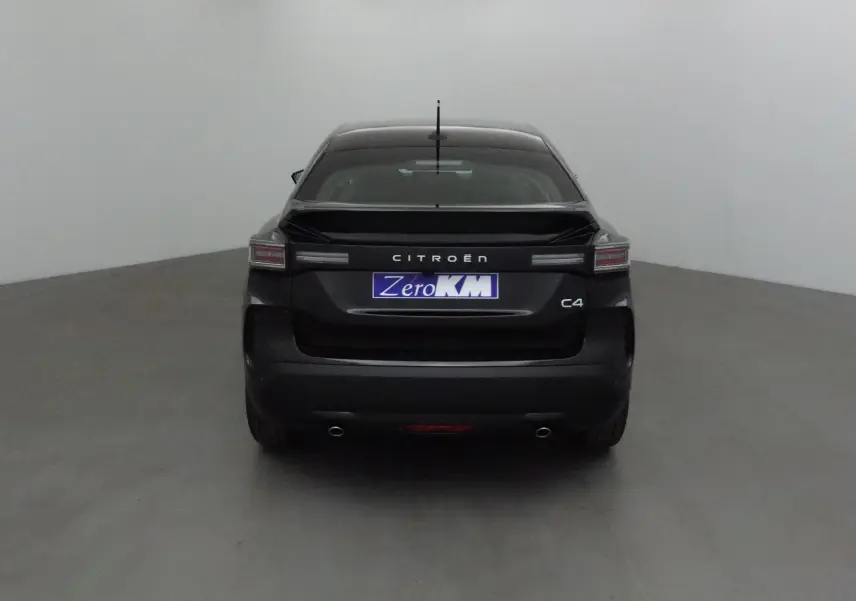 Vue arrière d'une Citroën C4 noire 2025 avec feux horizontaux et double sortie d'échappement visibles.