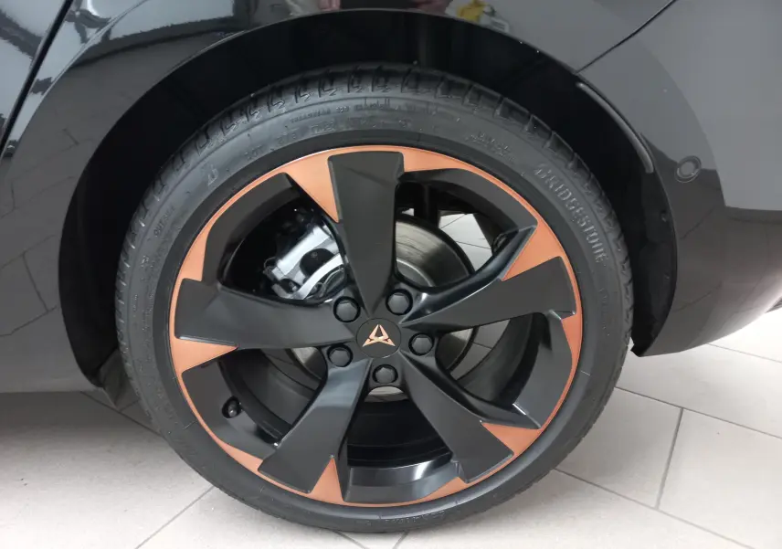 Gros plan sur la jante cuivrée et noire de 18 pouces du côté arrière droit d'une CUPRA Leon Noir Minuit 2025.