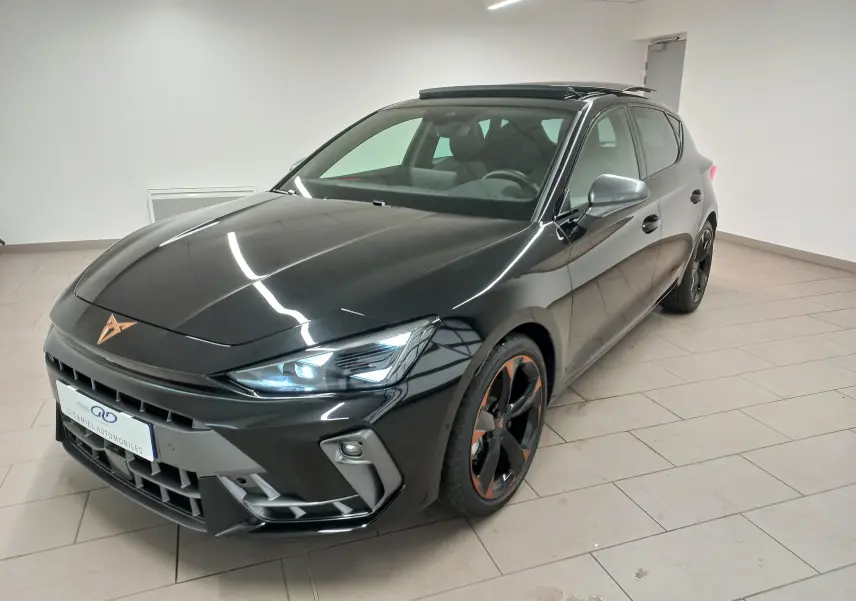Vue 3/4 avant droite d'une CUPRA Leon noire Minuit avec jantes cuivrées et toit ouvrant panoramique en intérieur showroom.
