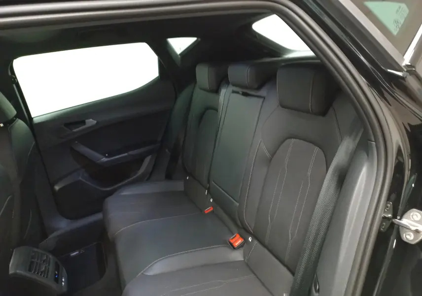 Vue intérieure côté droit des sièges arrière noirs de la CUPRA Leon 2025 avec toit ouvrant panoramique visible.