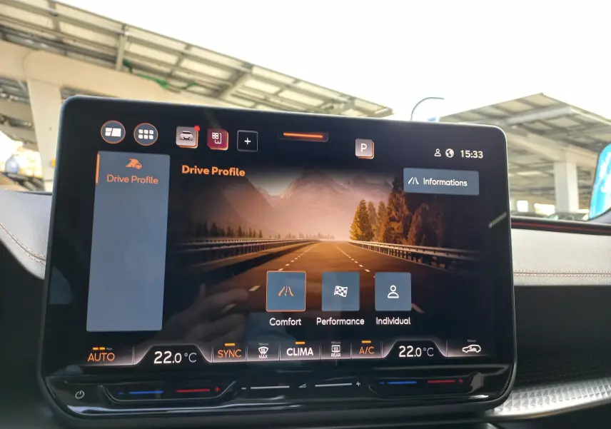 Écran central tactile du tableau de bord du CUPRA Leon 2025 affichant les modes de conduite et la climatisation.