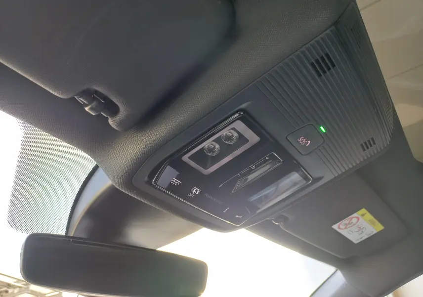 Vue intérieure du plafonnier noir avec commandes d'éclairage et bouton SOS du CUPRA Leon 2025 toit ouvrant panoramique.