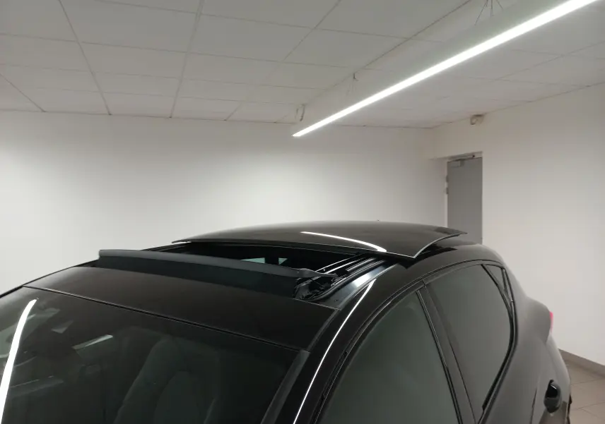 Toit ouvrant panoramique ouvert sur le côté gauche d'une CUPRA Leon Noir Minuit vue en 3/4 arrière intérieur.