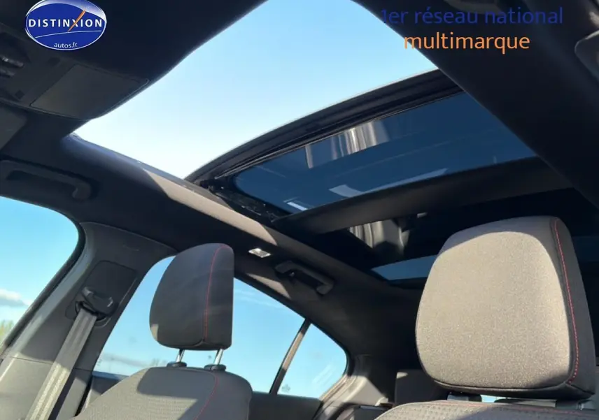 Vue intérieure de la Ford Focus 2024 noire, mettant en valeur les sièges avant et le toit ouvrant panoramique.