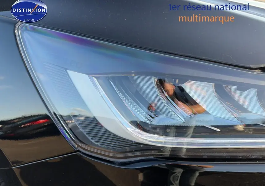 Gros plan sur le phare avant droit noir brillant de la Ford Focus 2024 avec détails LED et surface lisse.