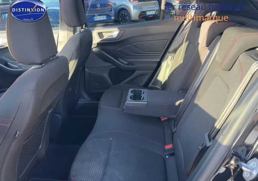 Vue intérieure côté droit de la banquette arrière noire avec accoudoir central et porte-gobelets de la Ford Focus 2024.