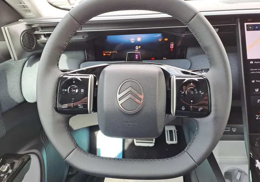 Vue rapprochée du volant noir mat de la Citroën C5 Aircross 2026, avec commandes tactiles et tableau de bord digital.