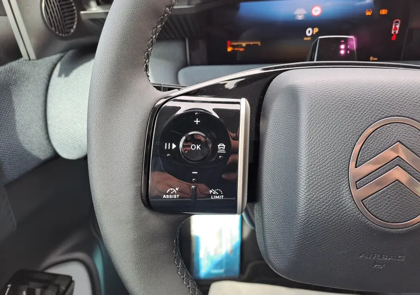 Gros plan sur le volant gris noir du Citroën C5 Aircross 2026, avec commandes tactiles et logo central visible.