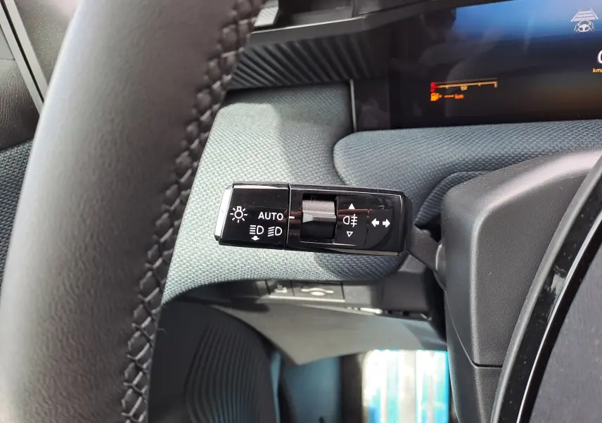 Gros plan sur la commande des feux et clignotants côté gauche du volant dans l’habitacle gris noir du Citroën C5 Aircross 2026.