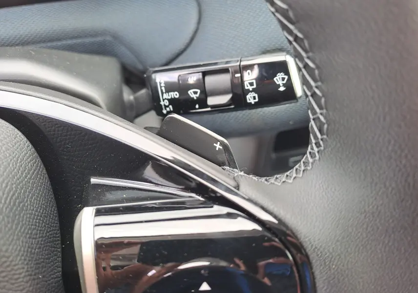 Gros plan sur la palette de changement de vitesse droite et commande d’essuie-glace du volant du Citroën C5 Aircross gris.