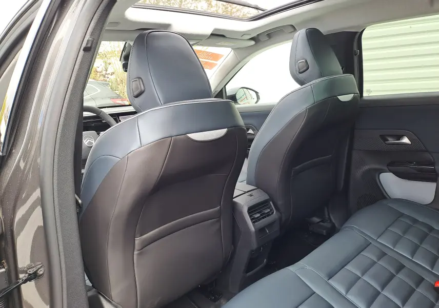 Vue arrière intérieure du Citroën C5 Aircross gris platinium, montrant les sièges avant en cuir noir et l'espace arrière.