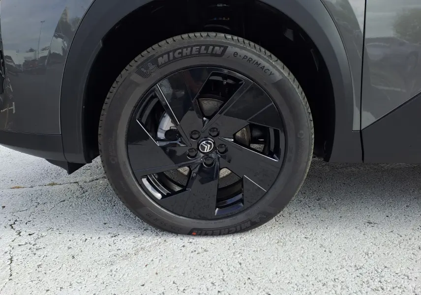 Gros plan sur la roue avant droite noire brillante du Citroën C5 Aircross gris platinium avec pneu Michelin.