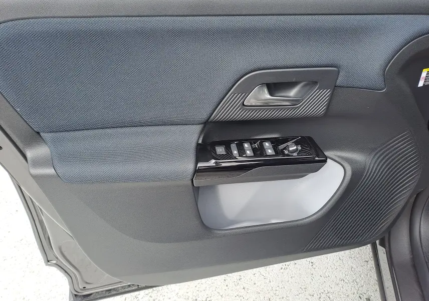 Gros plan sur la porte intérieure côté conducteur du Citroën C5 Aircross gris platinium, avec commandes de vitres et poignée noire.