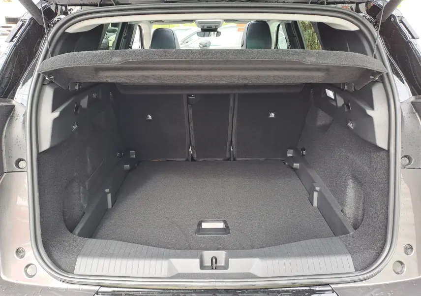Coffre ouvert vu de l'arrière d'un Citroën C5 Aircross gris platinium avec intérieur noir et banquette arrière visible.