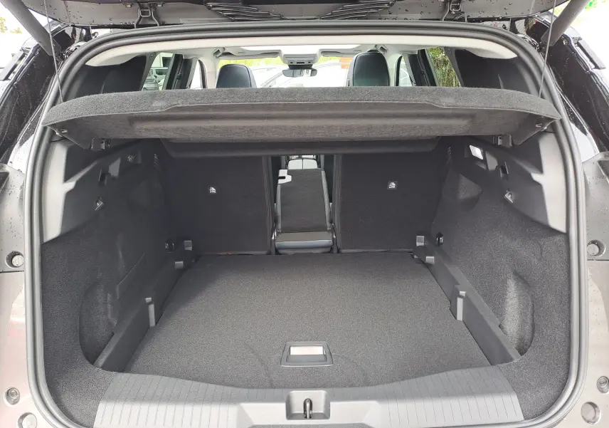 Vue arrière du coffre ouvert du Citroën C5 Aircross gris platinium avec banquette arrière partiellement rabattue.