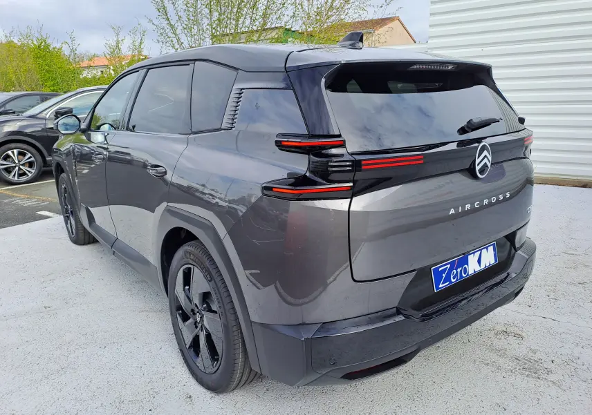 Vue 3/4 arrière droite d'un Citroën C5 Aircross gris platinium avec toit noir et feux arrière LED distinctifs.