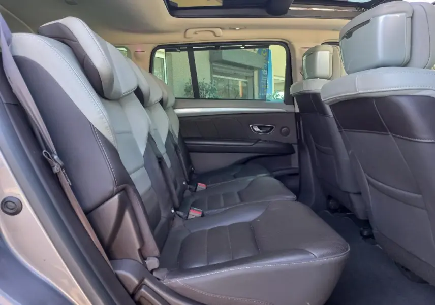 Vue intérieure côté gauche du Renault Espace gris 2017, montrant les sièges arrière en cuir bicolore et le toit panoramique.