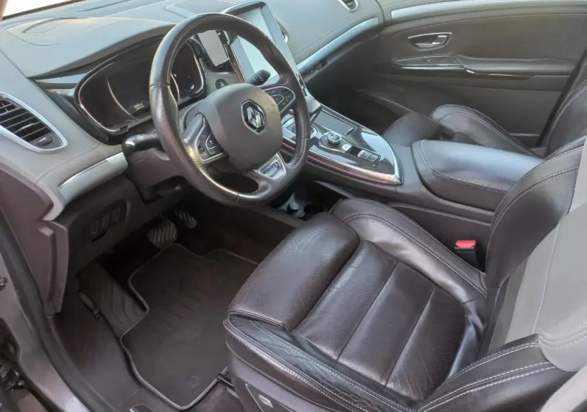 Vue intérieure côté conducteur du Renault Espace gris 2017, avec volant cuir et console centrale moderne.