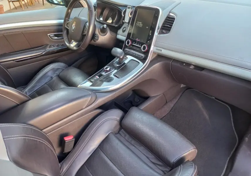Vue intérieure côté conducteur du Renault Espace gris 2017, mettant en valeur le tableau de bord et la console centrale tactile.