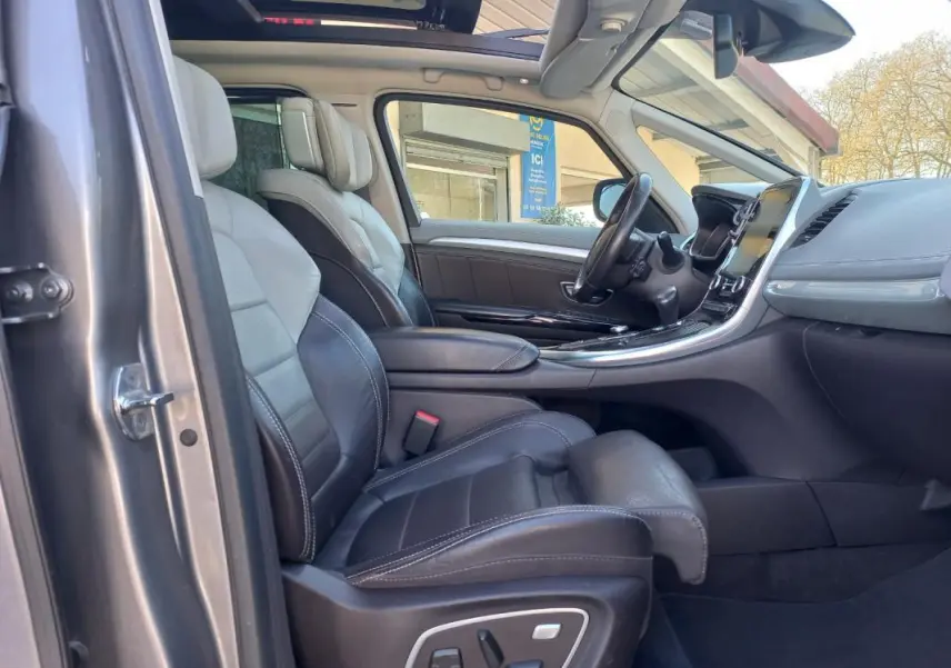 Vue intérieure côté conducteur du Renault Espace gris 2017, mettant en valeur les sièges cuir et la console centrale moderne.