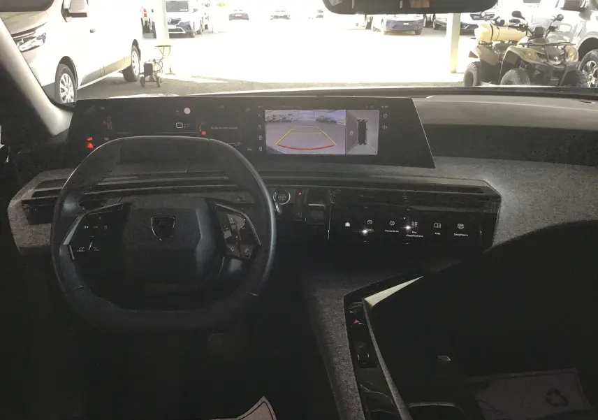 Vue intérieure côté arrière droit du Peugeot 3008 1.2 Hybrid 145 Allure, sièges tissu et cuir gris avec surpiqûres contrastées.